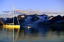 Crew from the 88 foot sloop "Shaman" taking the tender ashore under the midnight arctic sun, Spitsbergen, Svalbard, Norway. Property Released.