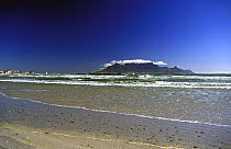 Looking across the sea from the beach at Blaauwberg Strand towards Table Mountain, Cape Town, South Africa.
