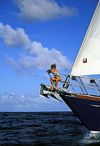 A young girl riding on the bow of "Realite", off the shores of St Maarten, Caribbean.