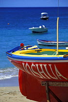 A brightly painted boat, "Joshua", sitting in her cradle on the shore during the Grenada Sailing Festival, Grenada, Caribbean.
