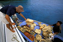 A local woman selling her crafts to the crew of a visiting yacht, Tonga, South Pacific.