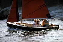 Young family sailing a Point Jude Daysailer off Bristol, Rhode Island, USA.