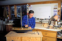 Model boat builder, Robert Eddy, working on the bow section of a scale model of the 1915 Herreshoff schooner "Mariette" in his shop in Camden, Maine, USA.