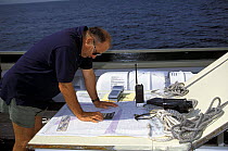 Navigation on the deck of tall ship "Gazella" showing early GPS hand held model and VHF on charts.