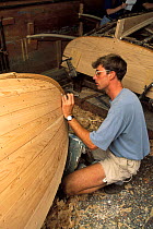 A traditional Beetlecat builder caulking the bottom of a new boat at the International Yacht Restoration School in Newport, Rhode Island, USA.