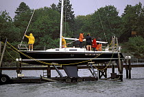 Preparing to haul a yacht onto the marine railway in stormy weather, New England, USA.