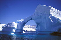 A large archway in a naturally carved iceberg, Antarctic Peninsula.
