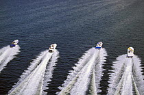 Four outerlimits powerboats powering away in a line.