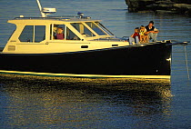Family cruising aboard a True North 38 motorboat in Narragansett Bay, Rhode Island, USA.