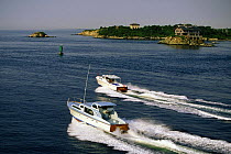Two Huckins power boats motoring past Clingstone off Jamestown, Rhode Island, USA.