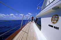 Crewman aboard the 170ft Perini Navi superyacht "Liberty" carrying sheet along the windward deck.