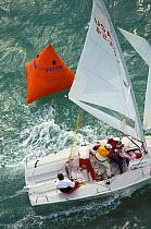 The crew of a Melges 24 hauling in the spinnaker at the leeward mark, Key West Race Week, Florida, USA.