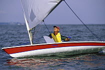 Older man sailing a Laser dinghy downwind with the centreboard up and weight forward.