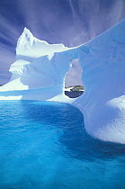Carved iceberg with cloud formations in the background, Antarctic Peninsula.