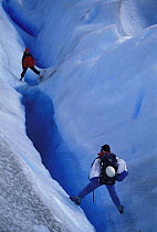 Two explorers evaluating the possibility of diving in a flooded crevasse, Perito Moreno glacier, Los Glaciares National Park, Patagonia, Argentina