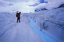 An alpinist watching a river flowing on the surface of Perito Moreno glacier, Los Glaciares National Park, Patagonia, Argentina