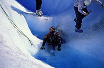 A diver ready to dive inside a crevasse full of water on the surface of Perito Moreno glacier, Los Glaciares National Park, Patagonia, Argentina