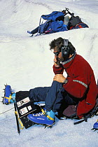 The expedition leader communicating with divers while they are immersed in a crevasse, using underwater communication equipment, Perito Moreno glacier, Los Glaciares National Park, Patagonia, Argentin...
