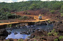 A four-wheel-drive car with kayaks on the roof driving through the Blue River Provincial Park on the southwest of Grande Terre, New Caledonia, Melanesia