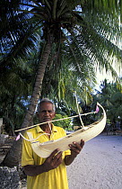 Man holding handmade model of a dhoni (the traditional Maldivian boat), Maldives.