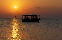 Dhoni, a traditional Maldivian boat, at sunset, Maldives.