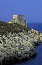 A fortification on the water's edge along the cliff lined coast at Dwejra, Gozo, Malta