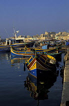 Kajjieks, traditional colourful eyed Maltese fishing boats. The painted eyes are supposed to keep evil away, Marsaxlokk harbour, Malta