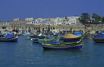 Kajjieks and luzzus, traditional colourful eyed Maltese fishing boats. The painted eyes are supposed to keep the evil off. Marsaxlokk harbour, Malta