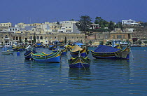 Kajjieks and luzzus the traditional colourful eyed Maltese fishing boats. The painted eyes are supposed to keep the evil off. Marsaxlokk Harbour, Malta.
