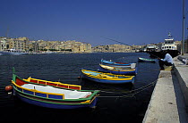 Traditional luzzu fishing boats moored in the harbour, Malta.