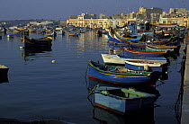 Kajjieks, the traditional colourful eyed Maltese fishing boats. The painted eyes are supposed to keep the evil off. Marsaxlokk Harbour, Malta