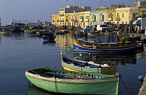 Kajjieks and luzzus, the traditional colourful eyed Maltese fishing boats. The painted eyes are supposed to keep the evil off. Marsaxlokk Harbour, Malta