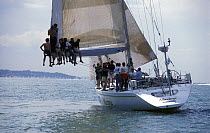 Crew of ^Maxima^ sit at the end of the boom to try and lever her off the mud at Brambles Bank during Cowes Week, 1998.