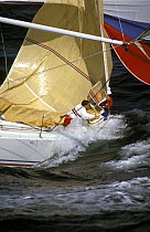 Two crewmen aboard "Abracadabra" lower the jib on the submerged bow after rounding the mark and hoisting the spinnaker during racing.