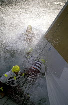 Crew aboard "The Card" are drenched as they change the headsail in the Southern Ocean. Whitbread Round the World Race, 1989-90.