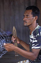Man mending fishing-nets on Balambangan island, Borneo, Sabah, Malaysia.