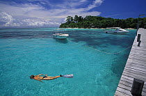 Snorkeling off pier at Lankayan island, Borneo. Model released.