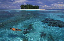 Snorkeling in clear waters off small and uninhabited Dondola Island, Togian Islands, Sulawesi, Indonesia. Model released.