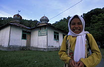 Muslim girl in front of mosque in Kondongan village, Walea, Togian Islands, Sulawesi, Indonesia.