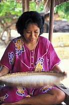 Baju woman drying rice at her home on the southern tip of Walea island, Sulawesi, Indonesia.