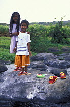 Two young girls standing on rocks, Mauritius. 2002