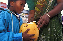 Young boy drinking coconut milk from a straw, Mauritius.