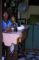 Woman using old-fashioned manual sewing machine, Puerto Princesa, Philippines. 2001