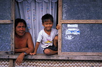 Father and son looking out of a window in Puerto Princesa, Palawan, Philippines. 2001