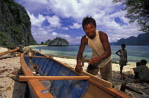 Man from the tagbanua tribe, Coron island, building a bangka (typical outrigger canoe).