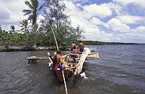 Men poling a popow, the traditional outrigger canoe used on Yap, Micronesia, with one man in the water. ^^^It is characterized by v shaped ends, used for travel and fishing. The popows are designed so...