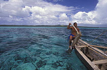 A popow, the traditional outrigger canoe used on Yap, Micronesia. A long pointed paddle is held overboard in the wake of the canoe to act as a rudder.