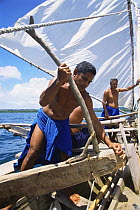 Men on a traditional outrigger canoe, the popow, Yap, Micronesia. The Popow is characterized by V shaped ends. They are designed so that the mast can be moved from one end to the other to reverse the...