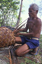Man weaving a handmade Yap style bag, Micronesia.