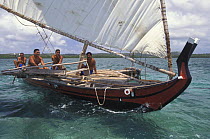 Men sailing a popow, the traditional outrigger canoe used on Yap, Micronesia. The popow is characterized by v shaped ends, used for travel and fishing. The popows are designed so that the mast can be...